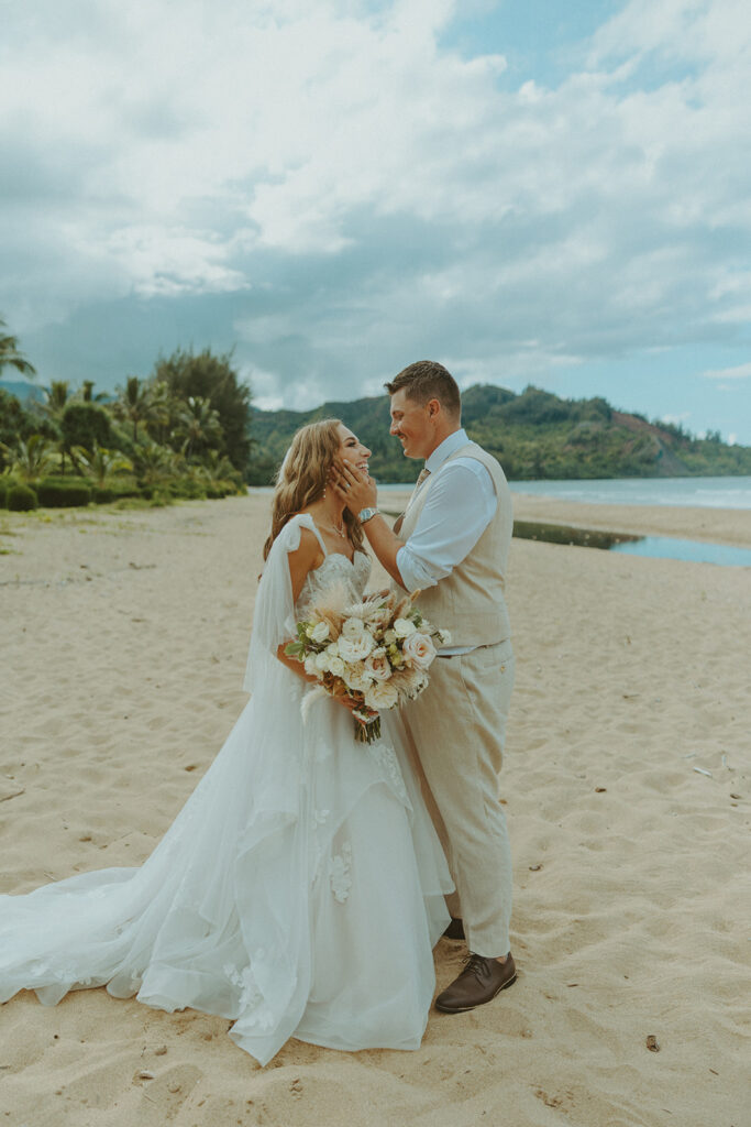 Newlyweds walking along a scenic coastal overlook in Kauai at sunset.
