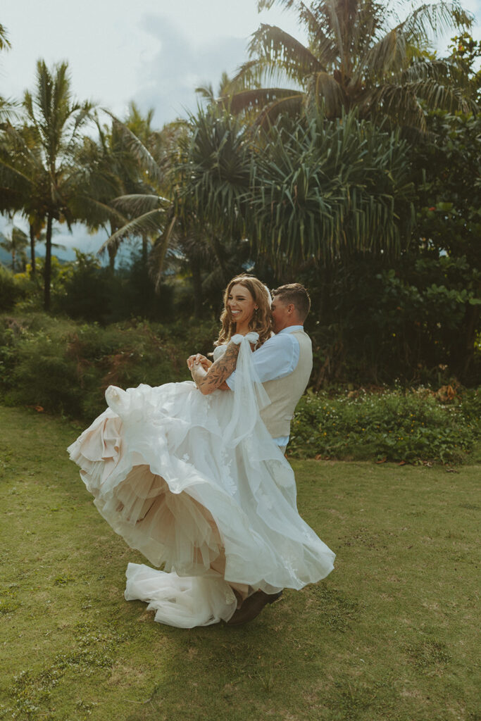 Bride and groom holding hands during an intimate beach wedding on Kauai’s north shore.
