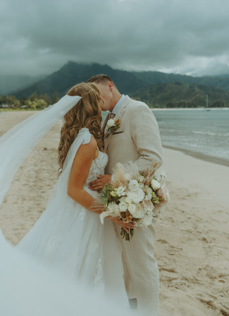 Bride and groom holding hands during an intimate beach wedding on Kauai’s north shore.
