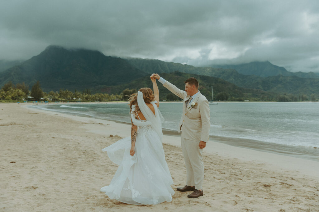 Bride and groom holding hands during an intimate beach wedding on Kauai’s north shore.