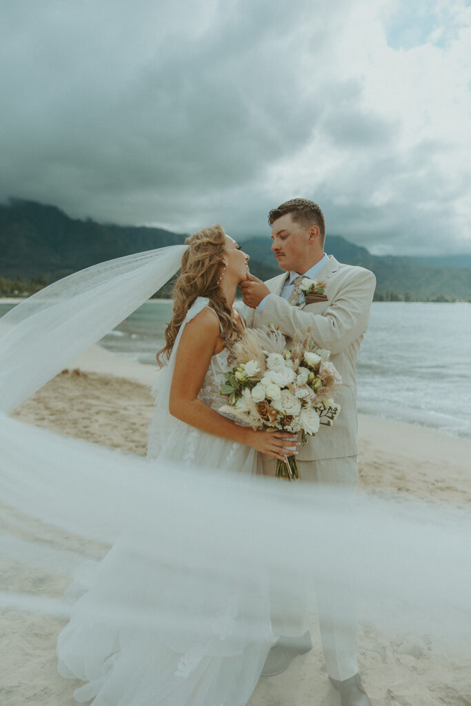 Bride and groom holding hands during an intimate beach wedding on Kauai’s north shore.
